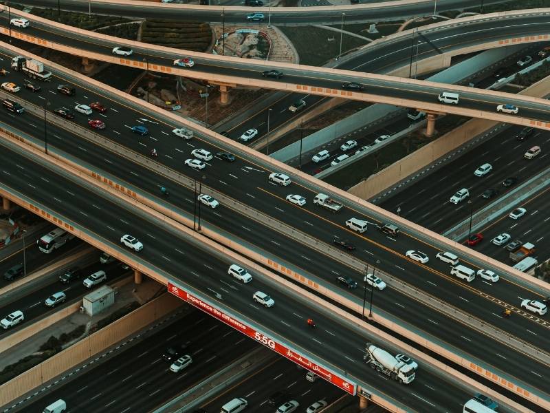 Aerial view of a busy highway interchange with multiple vehicles illustrating annual average daily traffic and roadway demand.